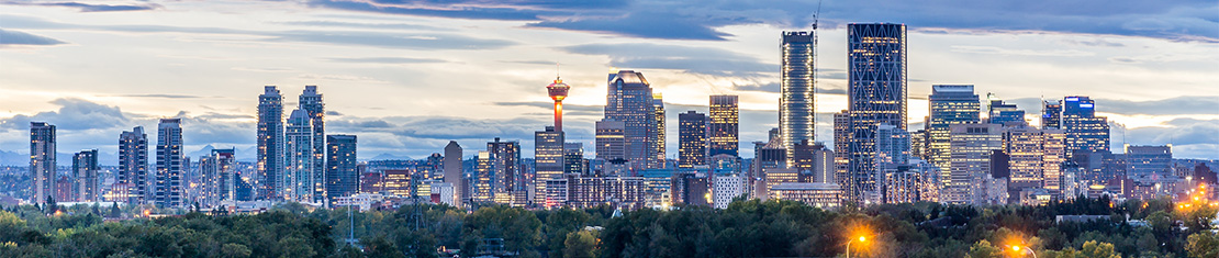 Downtown Calgary at dusk with city lights.