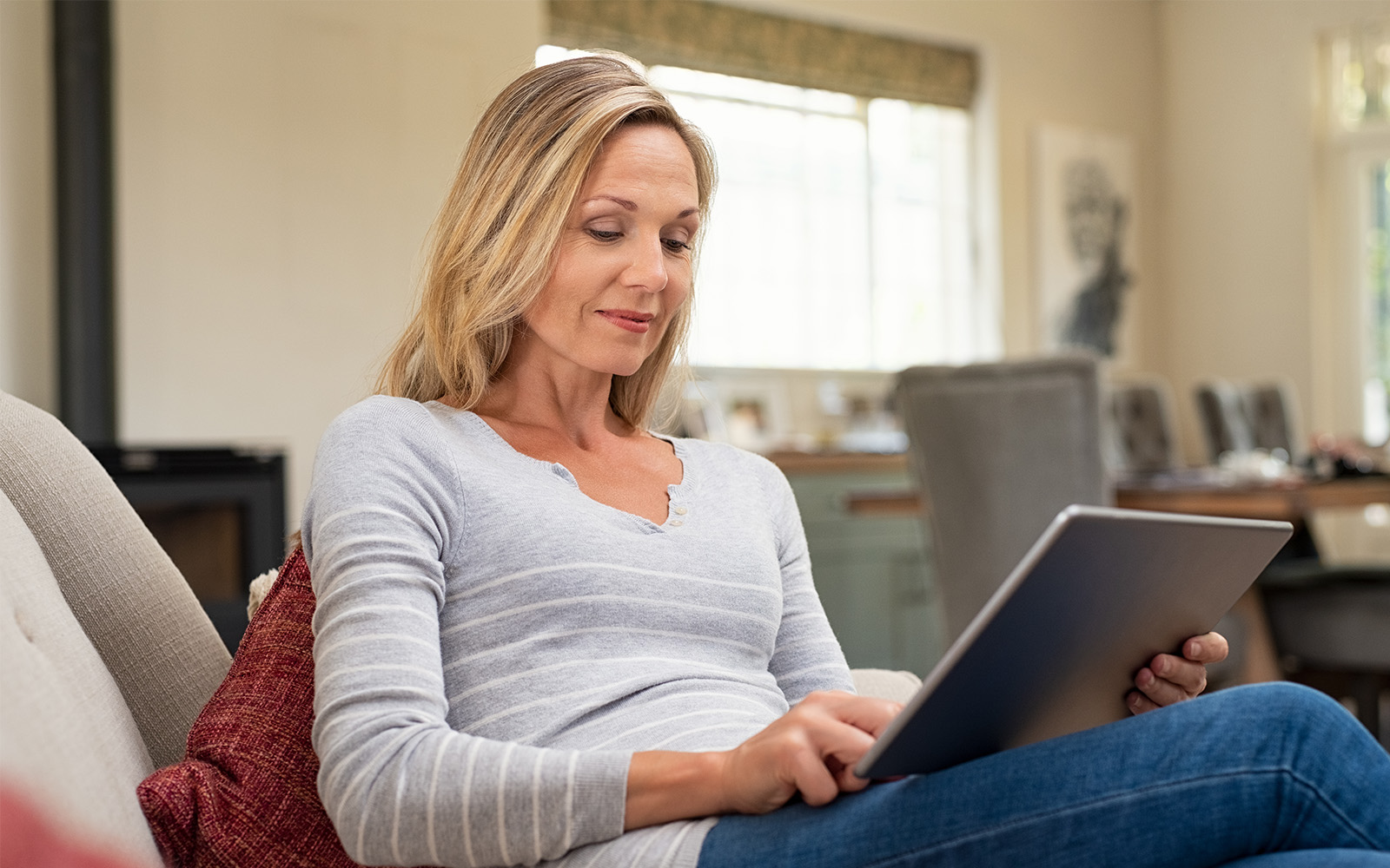 Woman sitting on couch and using digital tablet