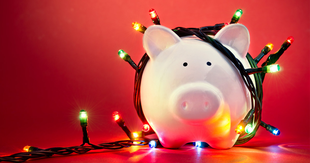 Piggy bank with string of Christmas lights wrapped around it