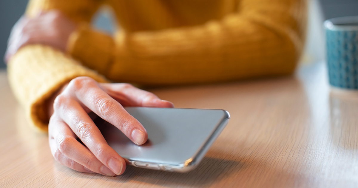 Concerned Woman Laying Mobile Phone Down On Table