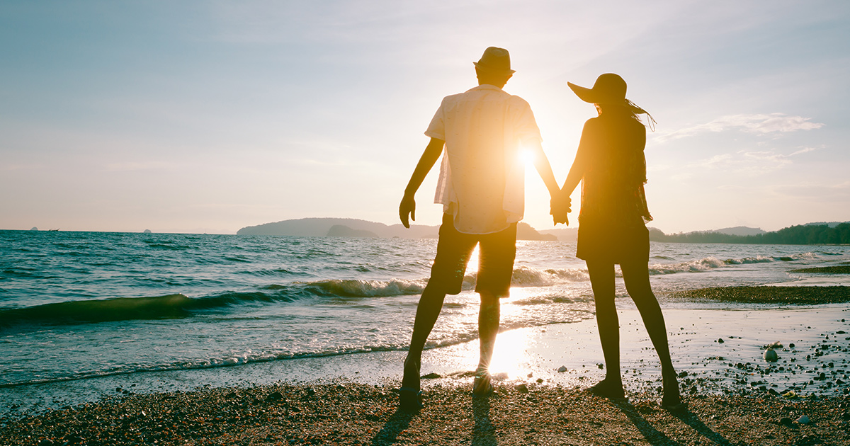 Middle aged couple enjoying beautiful sunset walk on the beach