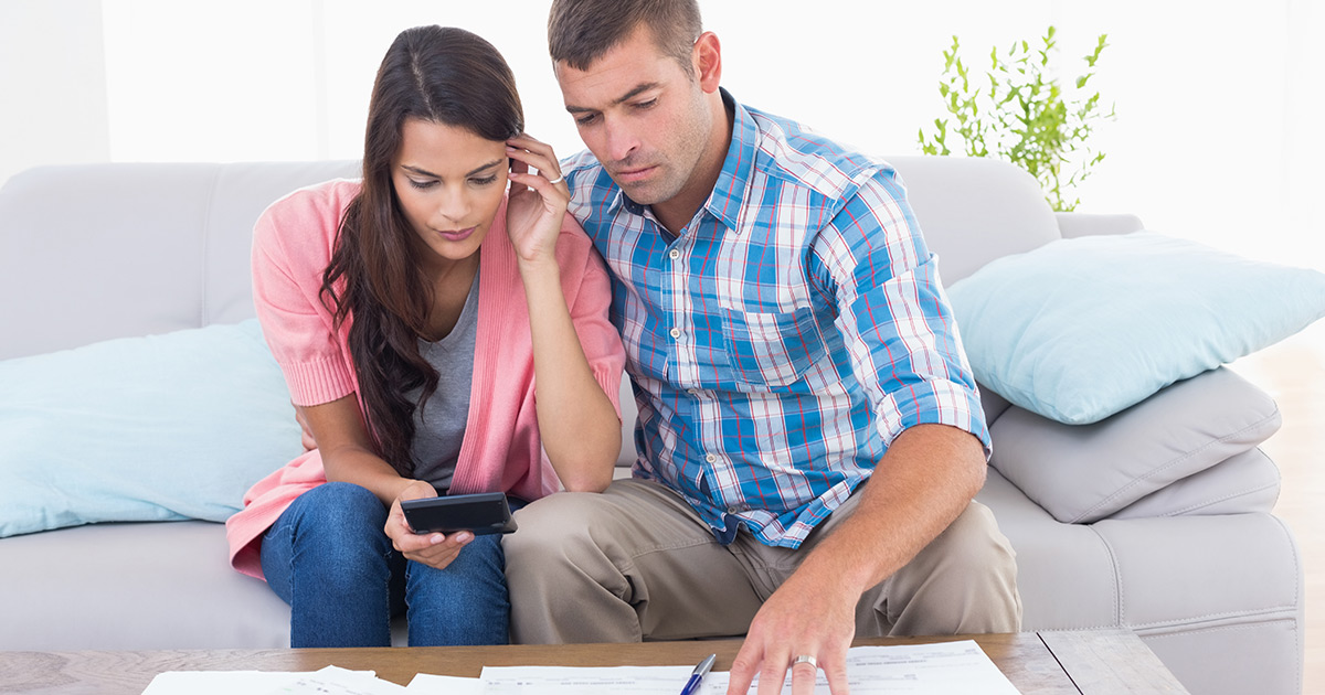 Couple calculating home finances together at the table 