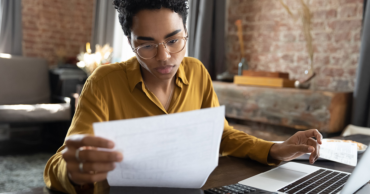 Woman looking through paper documents managing business affairs