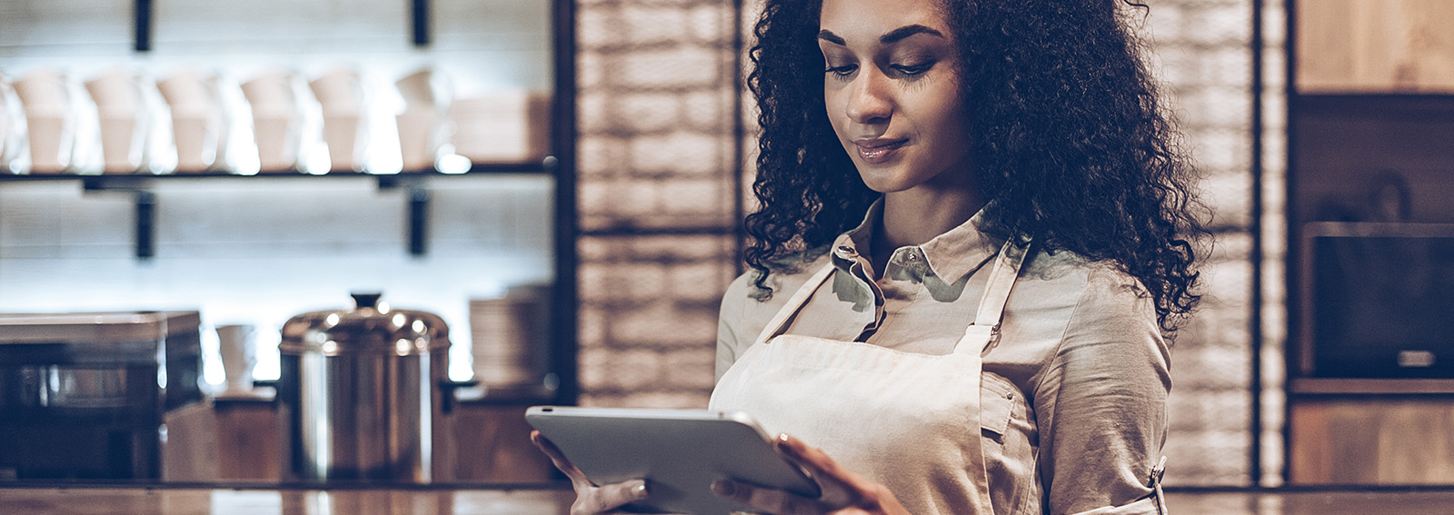 Business owner using her digital tablet while standing at bar counter