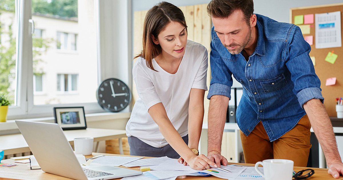 Busy Atlantic Canadian couple working at the office going over finances together.