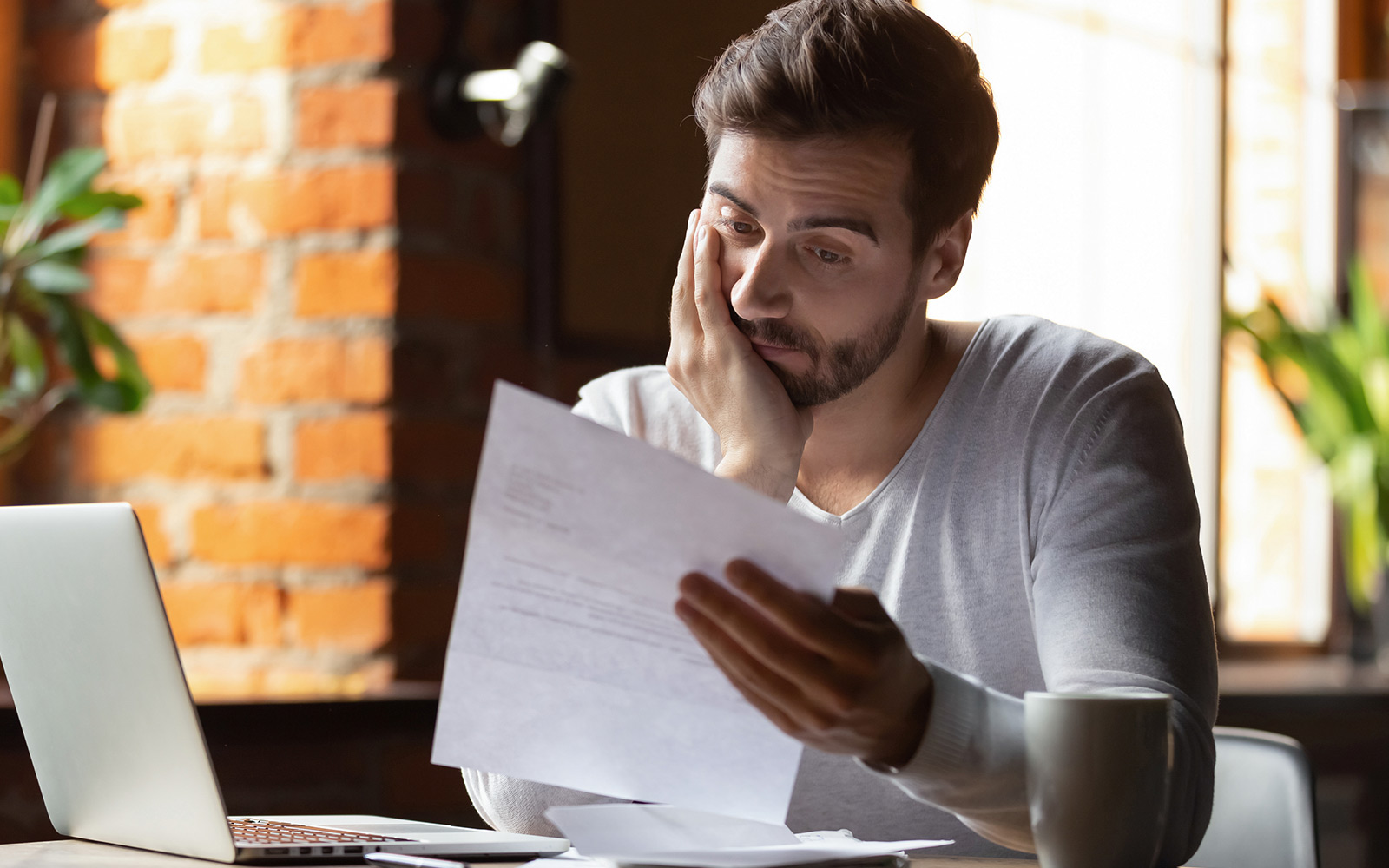 frustrated man reading debt notification letter