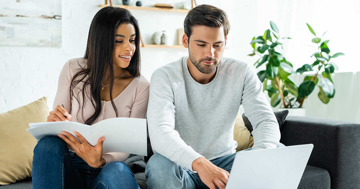 couple doing paperwork and using a laptop