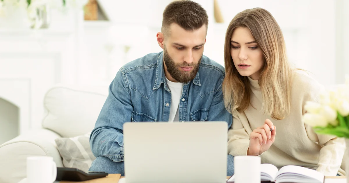Couple managing expenses with laptop and checking accountancy and bills