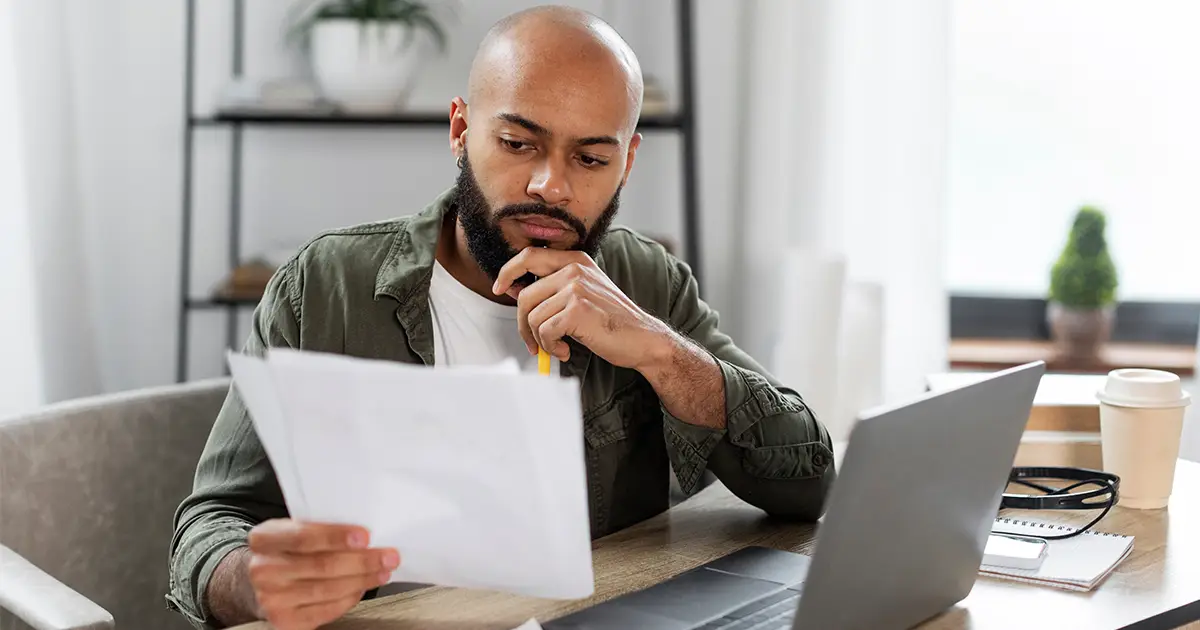 Checking documents reading financial reports while sitting at desk at home