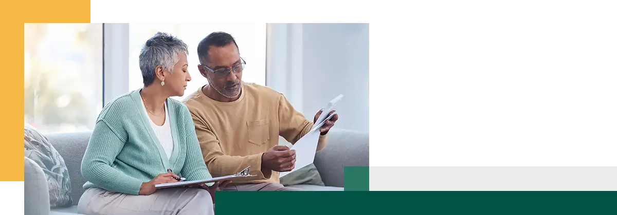 Finance documents and senior couple on sofa with bills