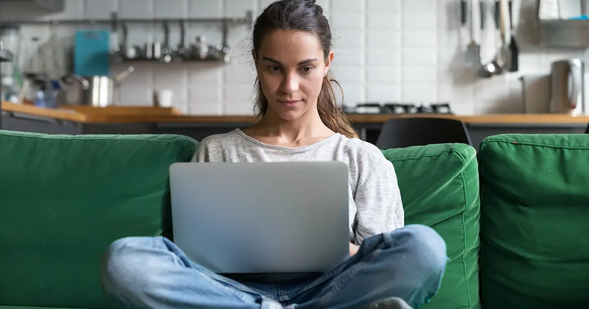 Serious woman using laptop working on computer