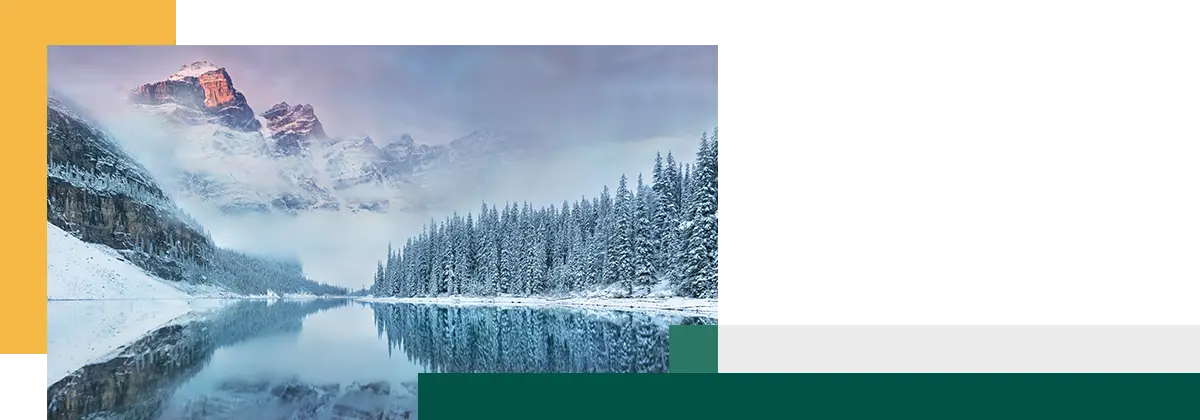 Snow-covered mountains and pine trees reflected in a calm lake