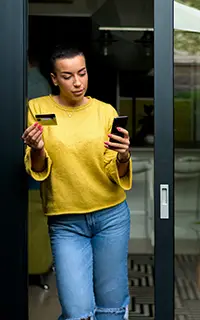 Portrait of casual relaxed woman using phone for online payment