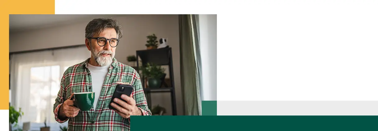 mature bearded man have fun while use mobile phone and drink coffee