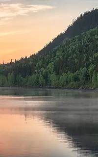Beautiful Morning Sunrise on a Steamy Lake Surrounded by Mountains With Trees in Quebec Canada