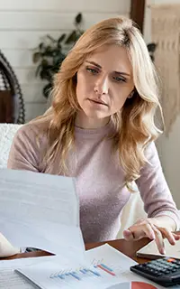 Focused woman looking through paper documents