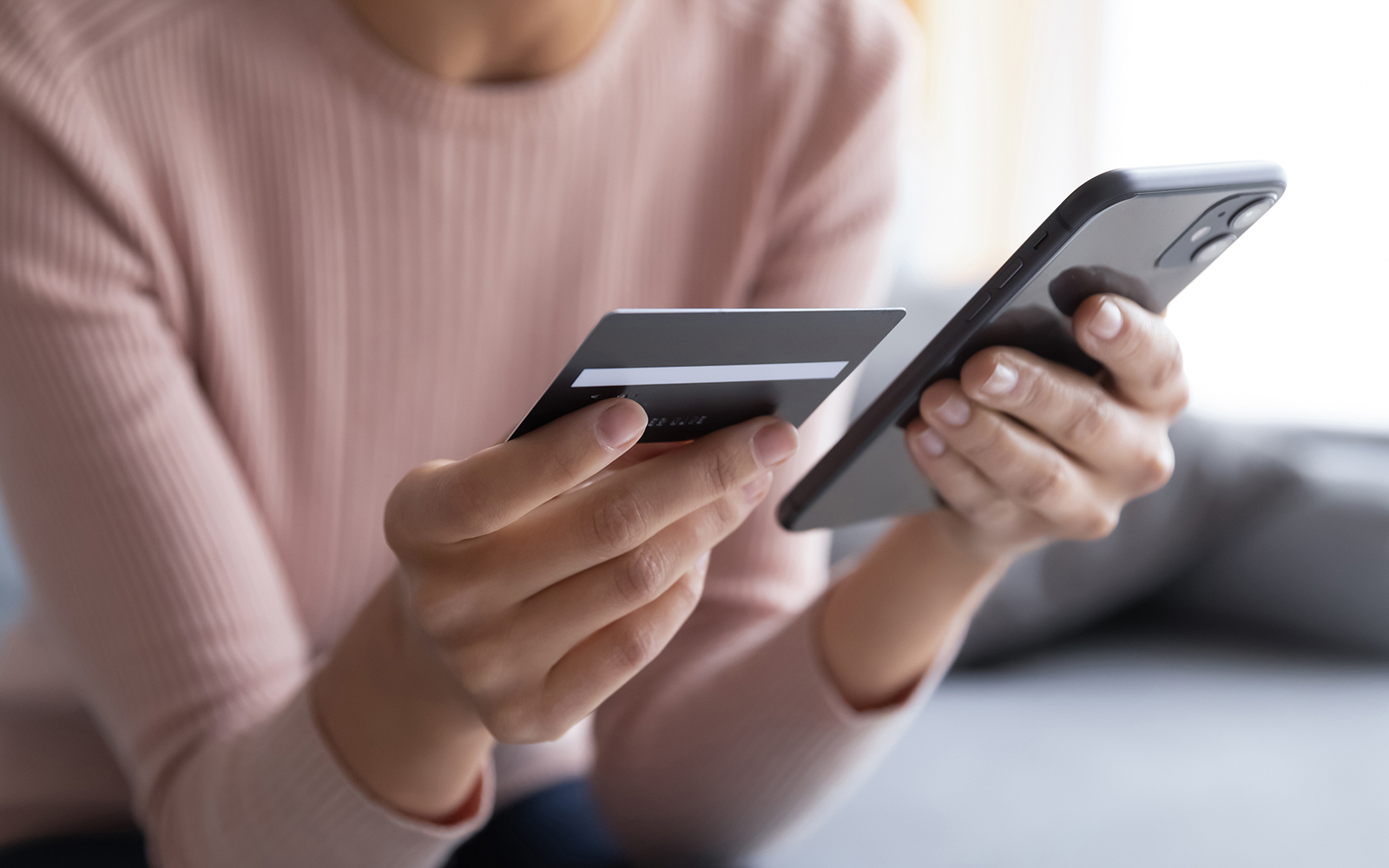 person holding credit card and phone