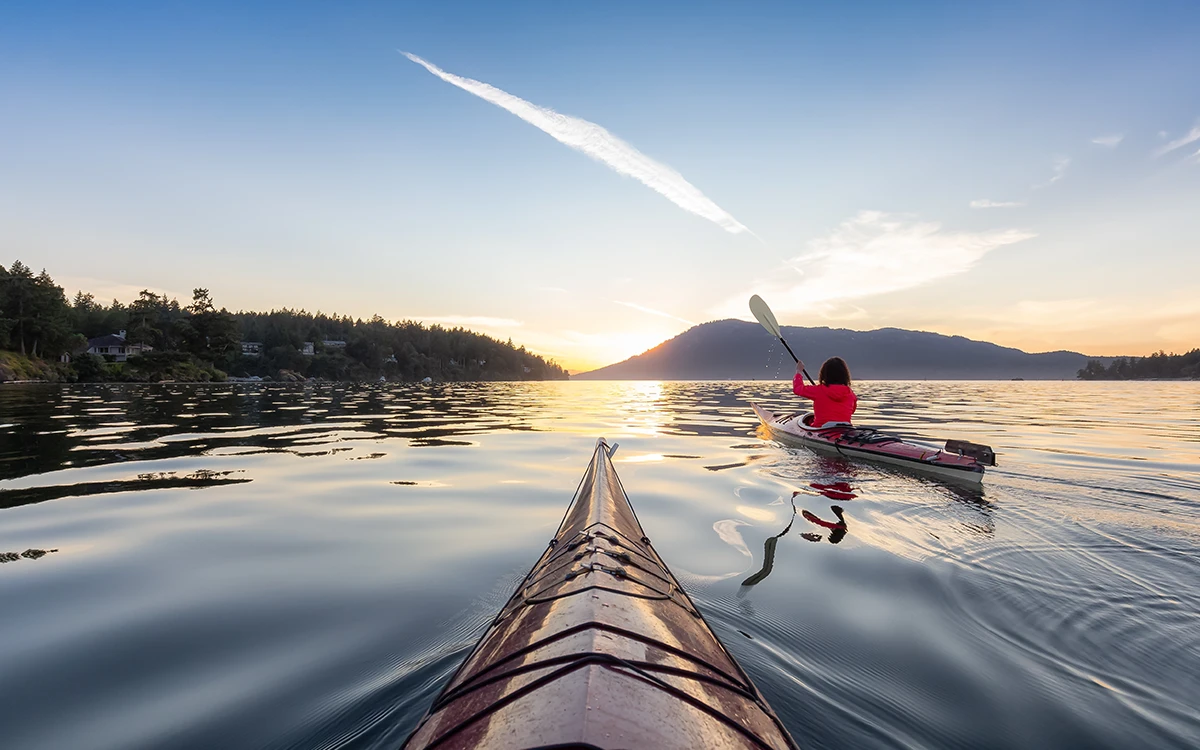 A woman kayaking on a lake in British Columbia.