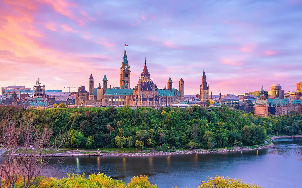 Parliament building in the distance with sunset behind it