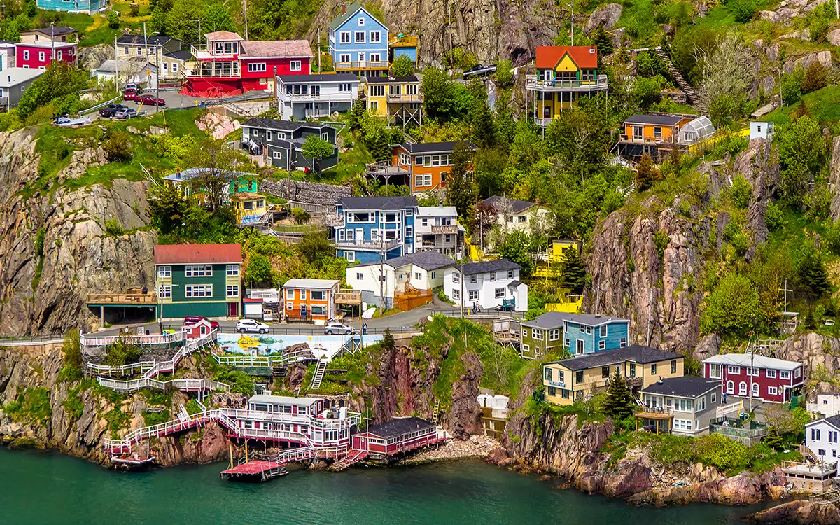 Scenic photo of a community showing multiple houses that are pastel colors along a coastline
