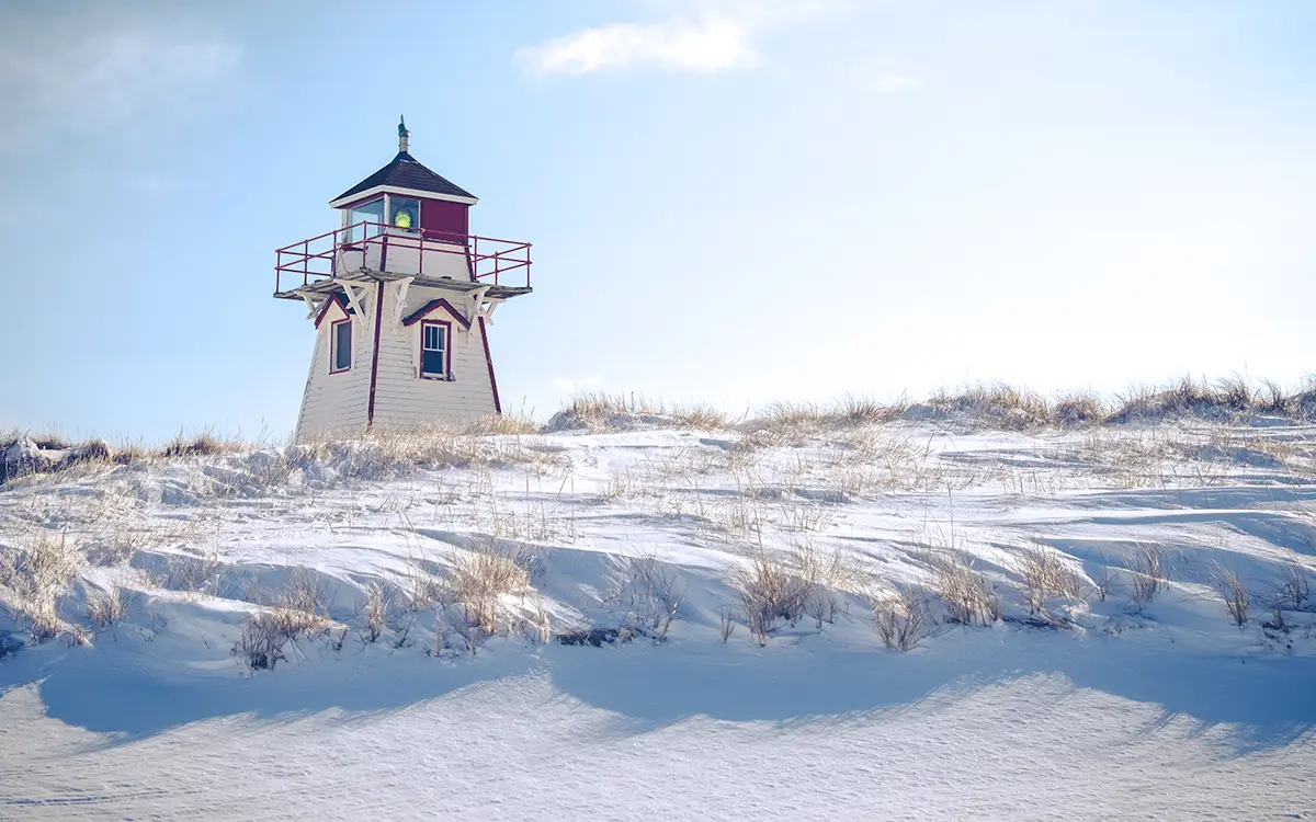 Lighthouse sitting on snow covered field