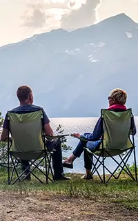 Young couple relaxing by Bow Lake, Banff National Park, Alberta, Canada