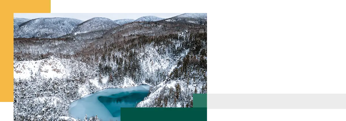 Valley covered in snow looking down a partially frozen lake