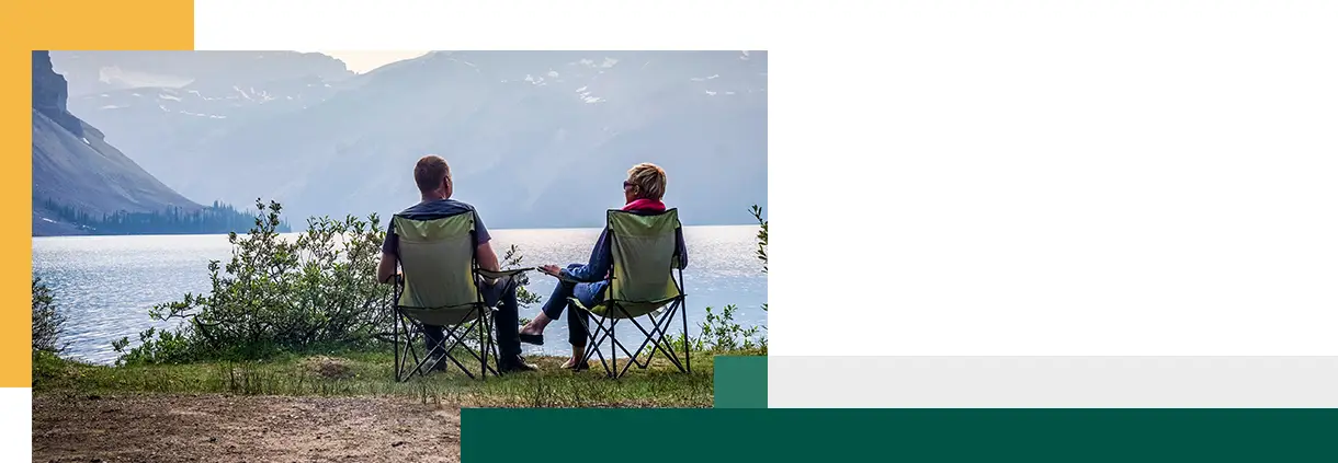 Young couple relaxing by Bow Lake, Banff National Park, Alberta, Canada