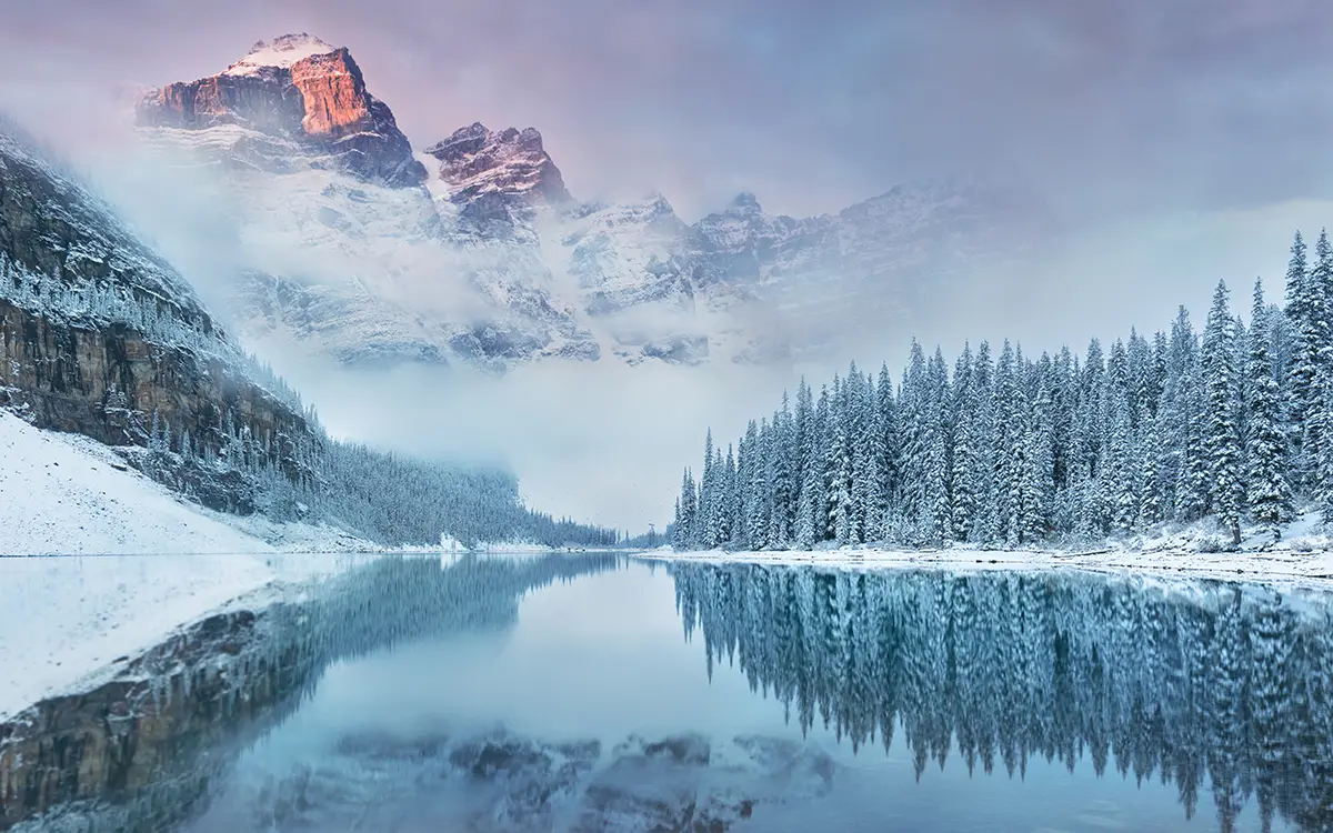 glacial lake in winter leading up to snow covered mountain