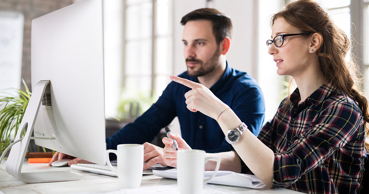 Young couple discussing finances in home office.