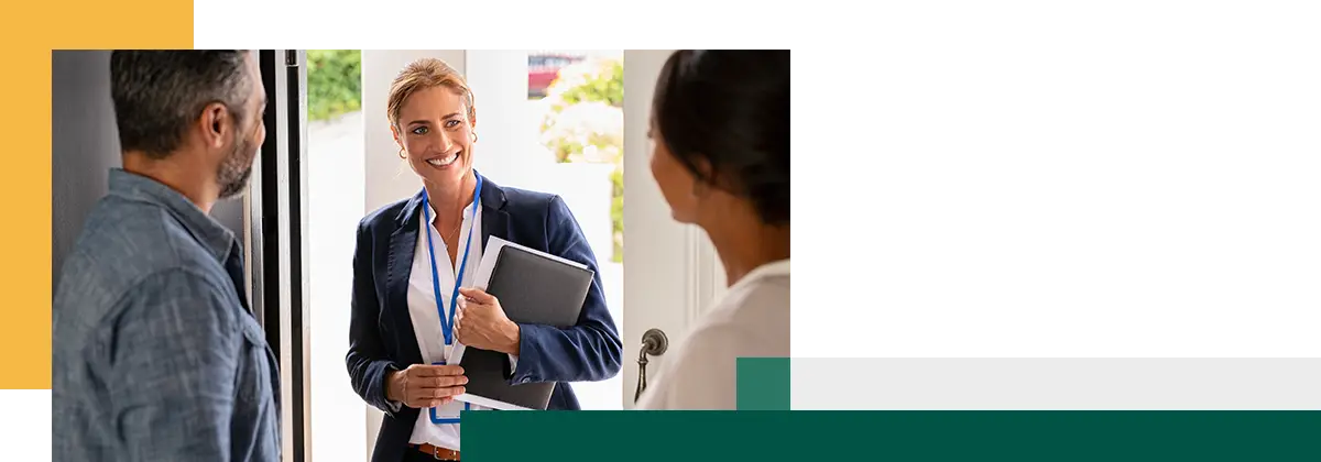man and woman greeting agent at home standing near door