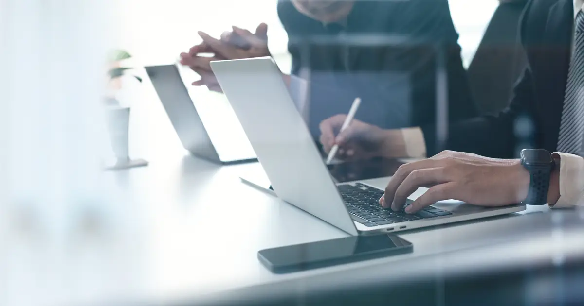 Two businessmen having a discussion working on laptop computer