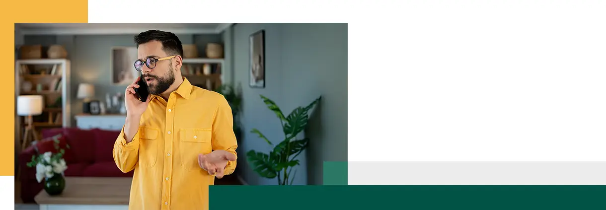 Man in yellow shirt on a tense phone call