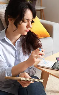 Young woman planning budget at home