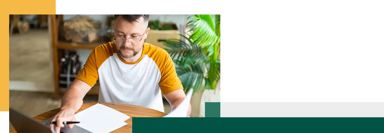 Photo of a middle-aged man working with his laptop at home