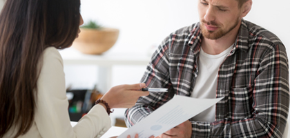 Licensed Insolvency Trustee holding up a piece of paper and advising a person on bankruptcy options.