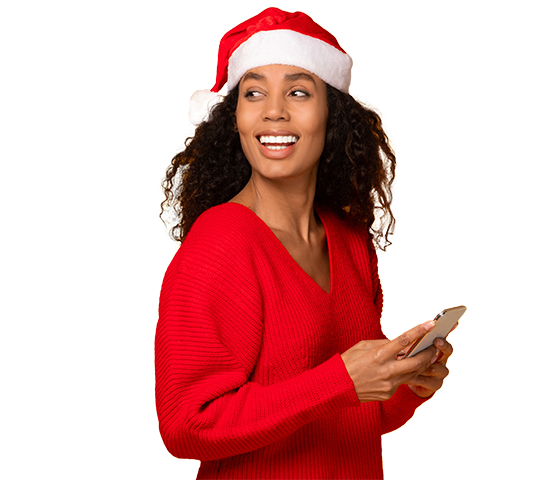 Woman wearing santa hat and holding mobile phone