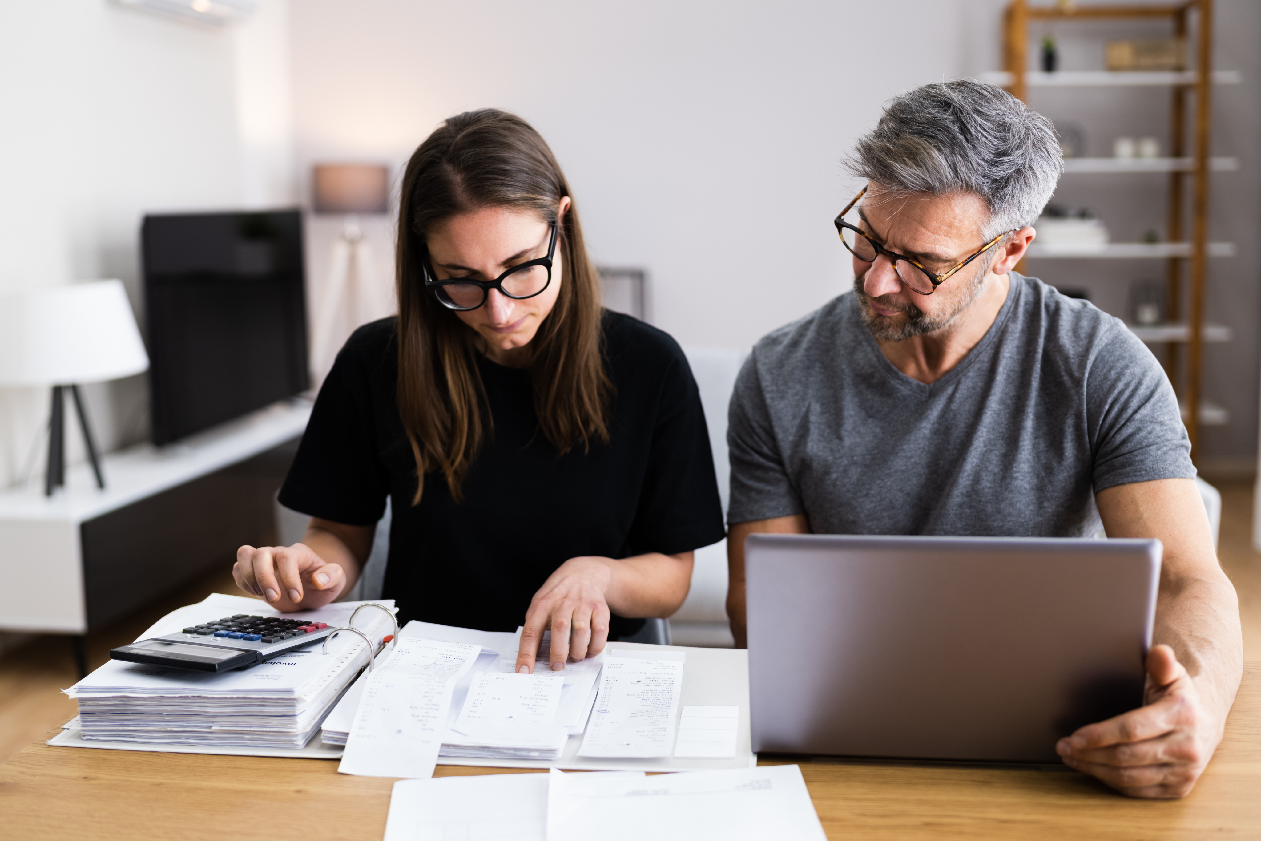 Couple reviewing a large stack of financial documents.