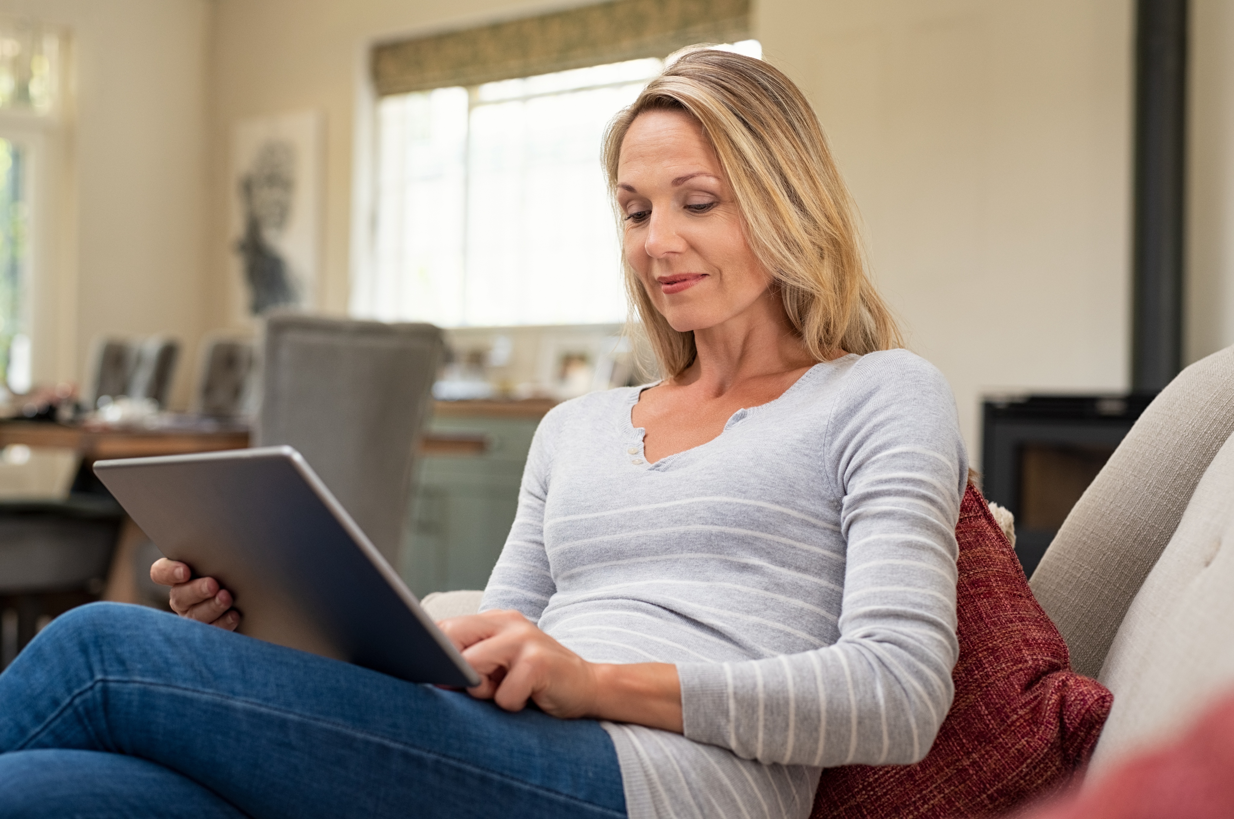Woman using a tablet computer to research debt relief options.