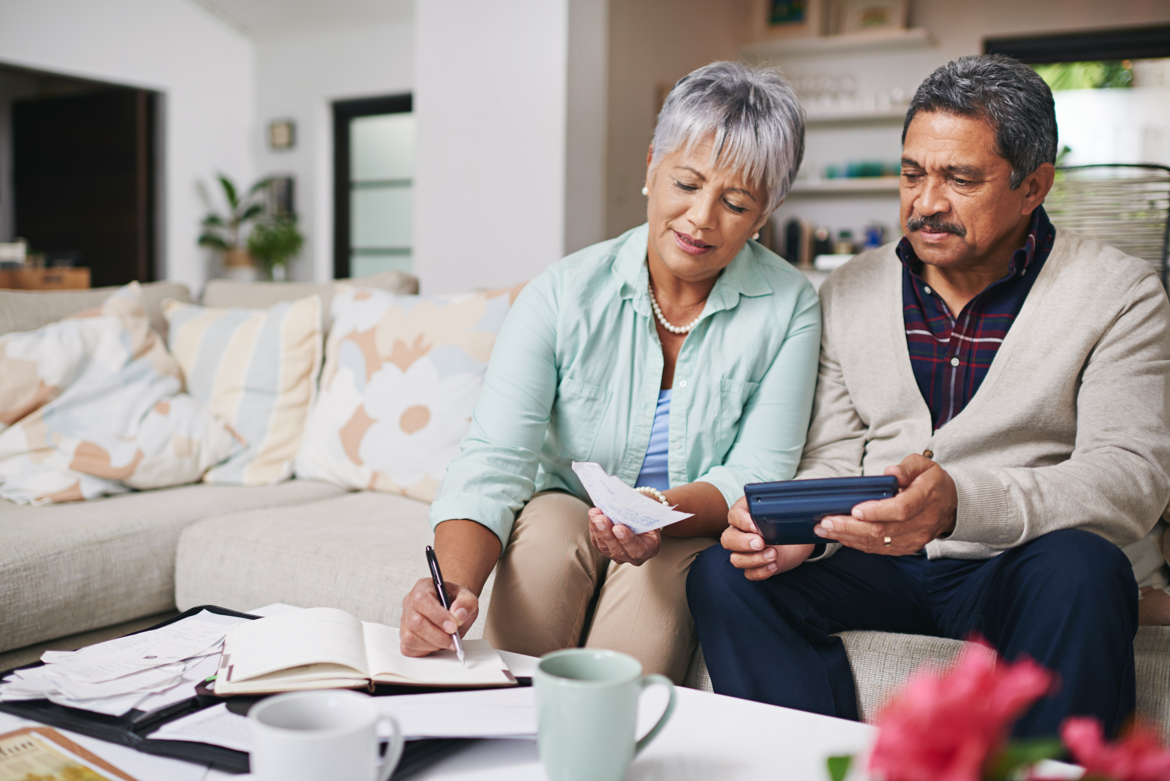 Couple sitting on the couch, reviewing their finances and debts.