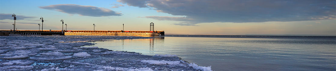 Cold Lake pier with ice floats sitting on the coast of a body of water.