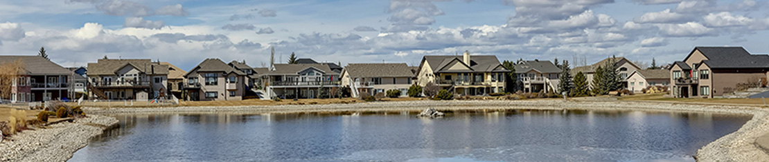 Cluster of houses in front of a body of water.