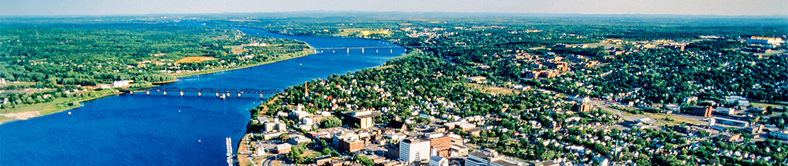 Aerial view of Fredericton along a body of water.