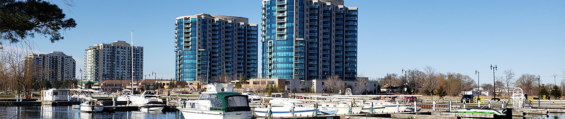 Skyscrapers beside a dock full of boats.