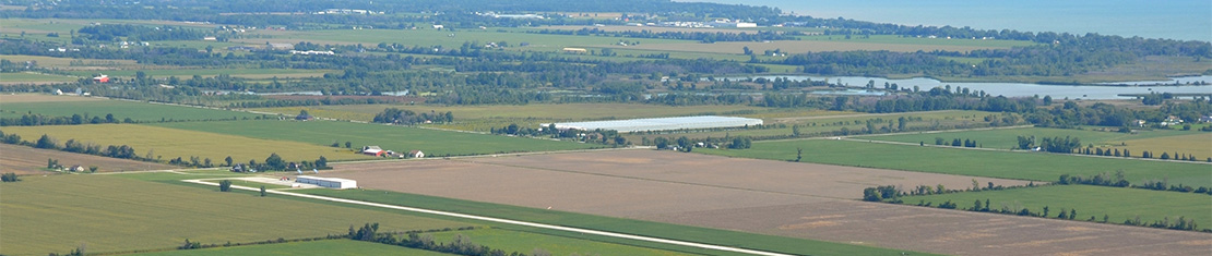 Aerial view of a patchwork of brown, green, and yellow fields.