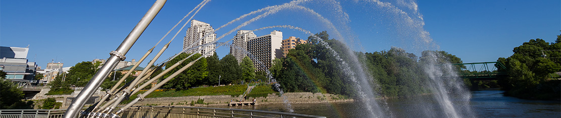 Water fountains in a park in front of skyscrapers