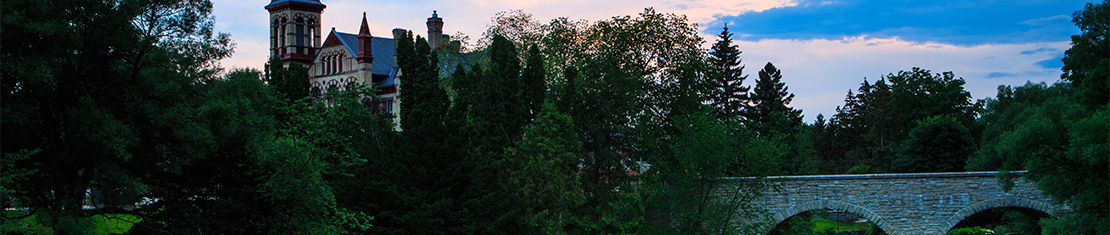Old stone bridge in front of a building with a clock tower