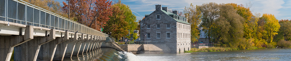Bridge leading to an old brick building near a body of water